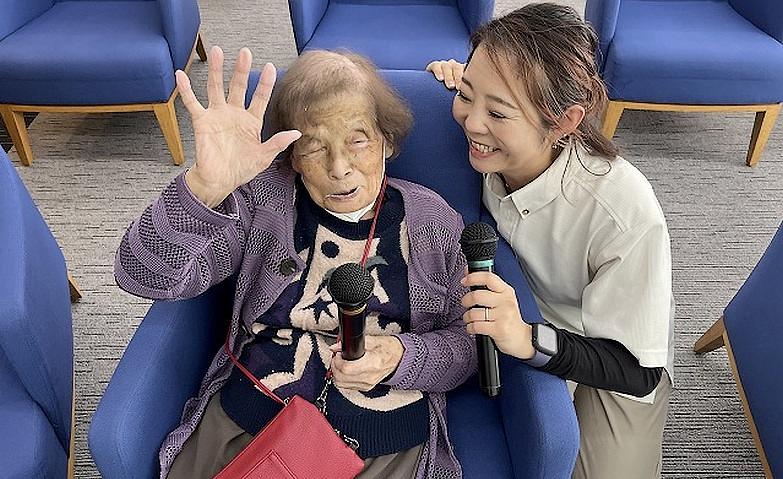 マイクをにぎって「ハイ、ポーズ！」