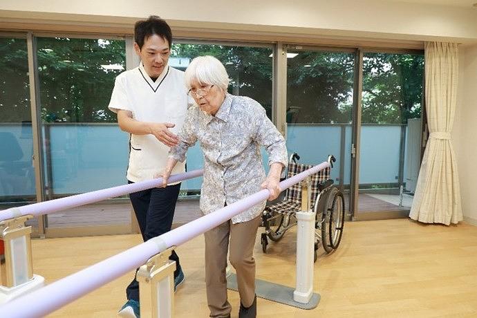 平行棒で歩行訓練をされるご入居者様
